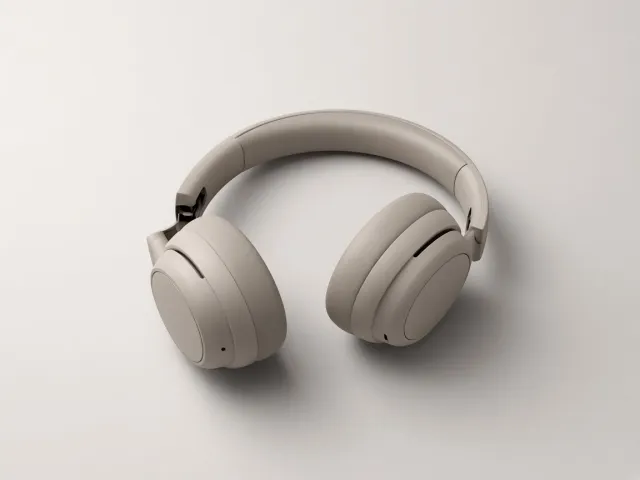 Sand colored over-ear headphones with a broken hinge